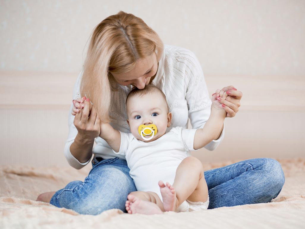 Woman sitting on floor playing with baby