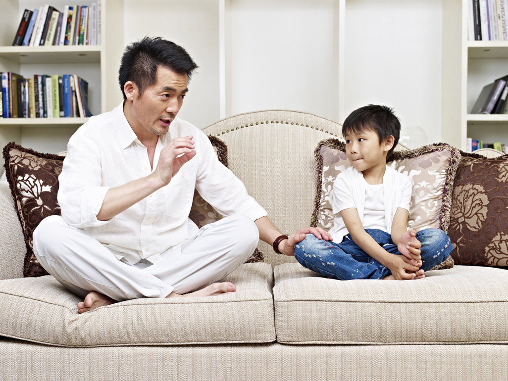 Dad talking to son on the sofa