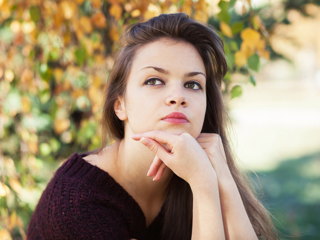 Woman sitting outside, looking annoyed