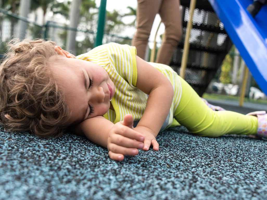 child sleeping on the ground