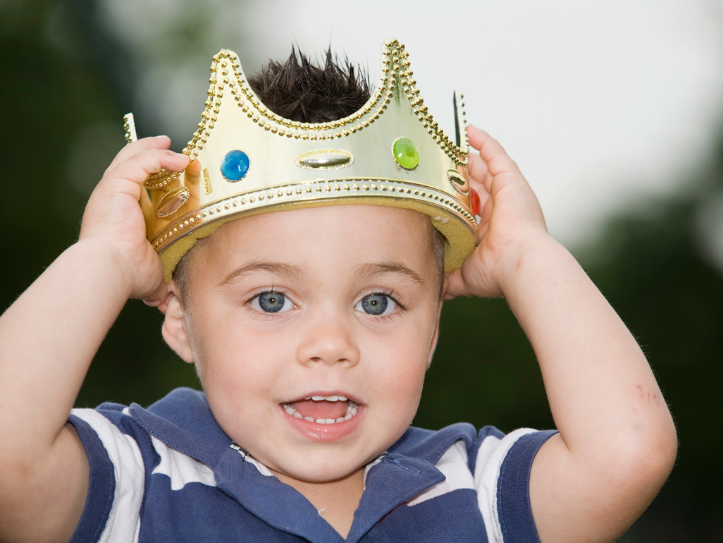 child holding a crown on his head