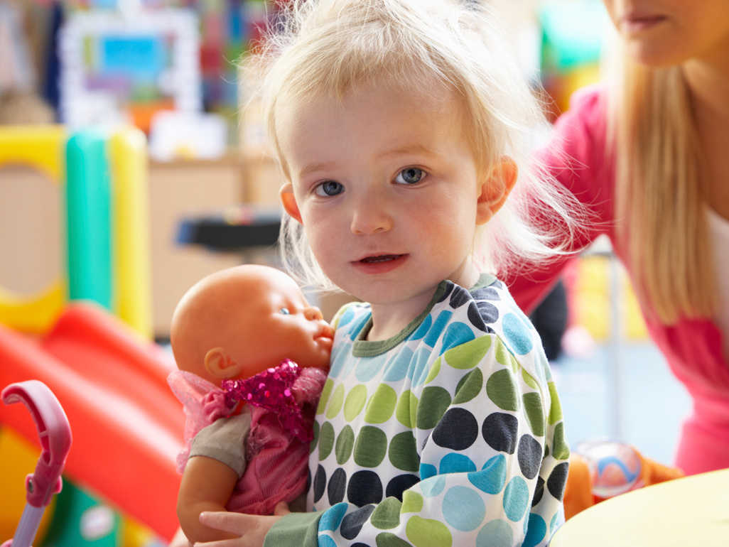 child holding a baby toy