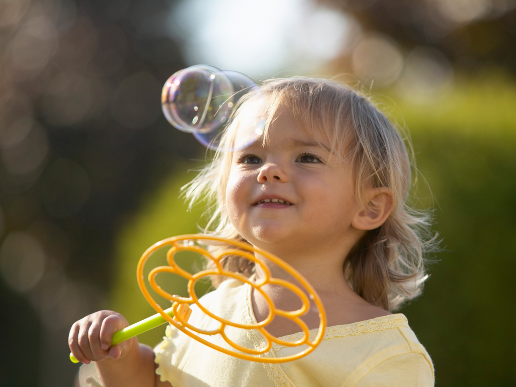 girl wondering at bubbles in the air