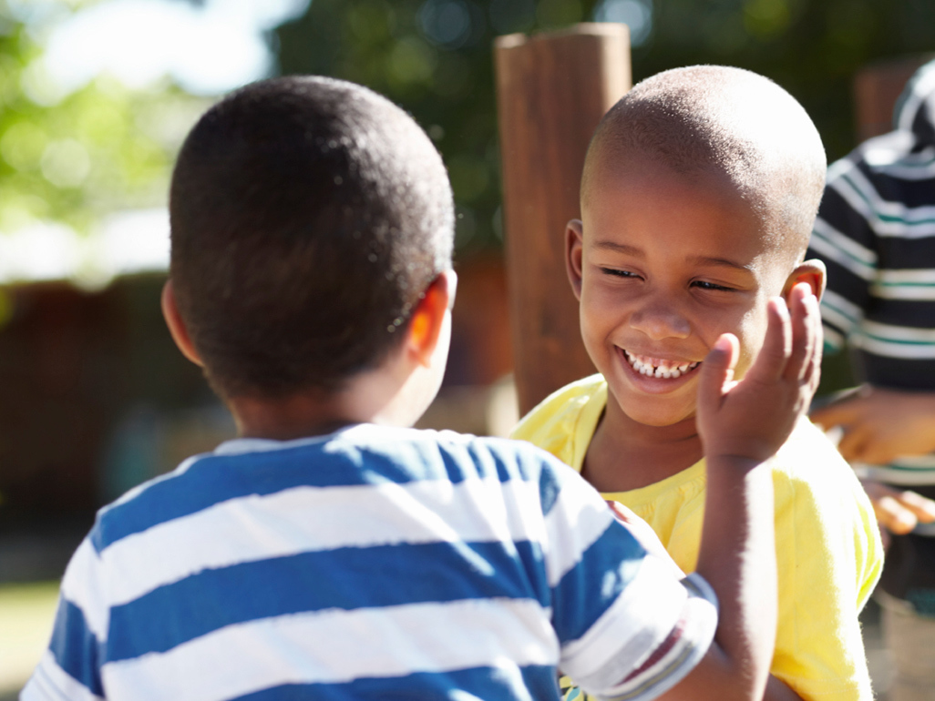 two kids talking to each other and laughing