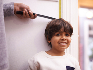 person measuring a height of a child