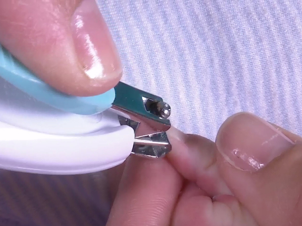 adult hands clipping a child's fingernails