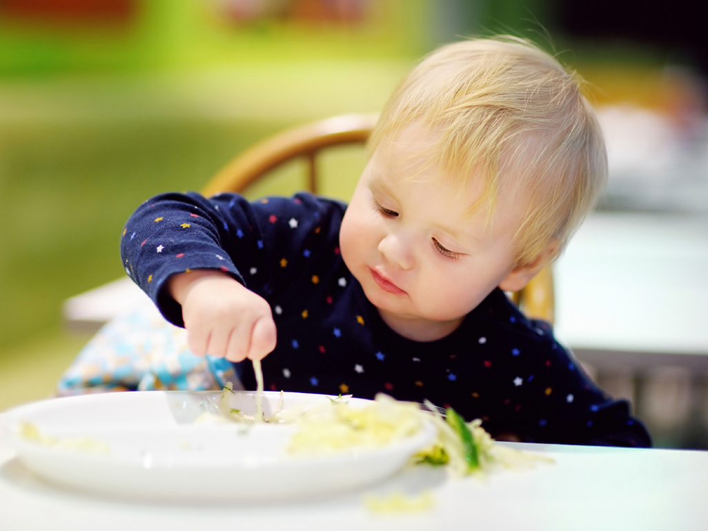 Toddler playing with his food