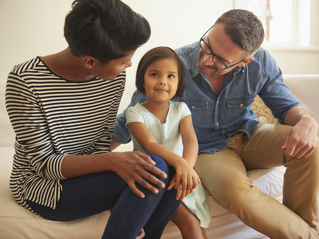 girl sitting between her parents, thinking