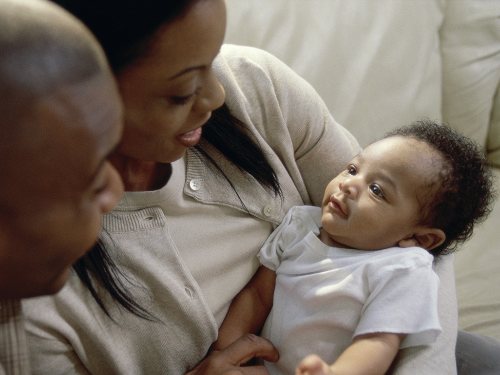 woman holding baby on couch