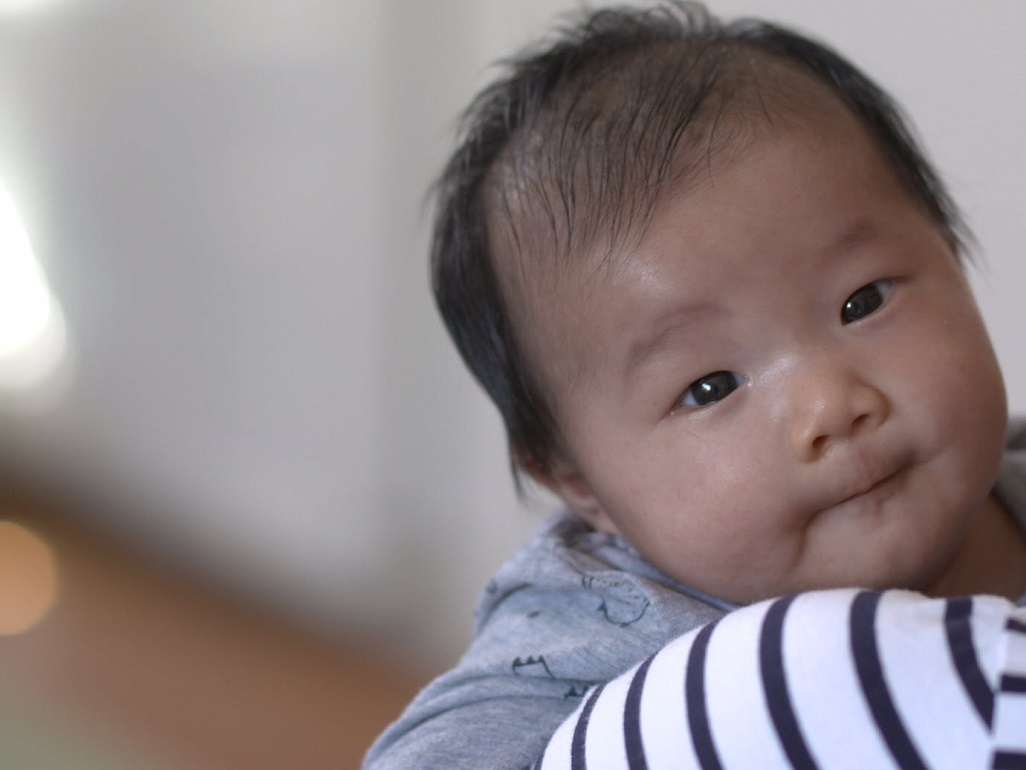 baby being held and looking at camera