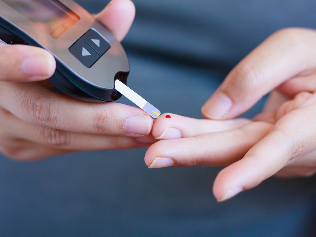 Pregnant woman testing her blood glucose levels