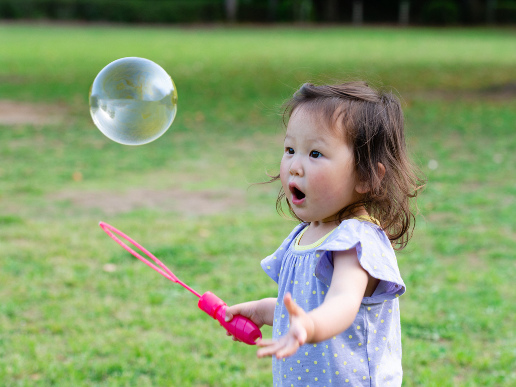 little girl playing with giant bubble