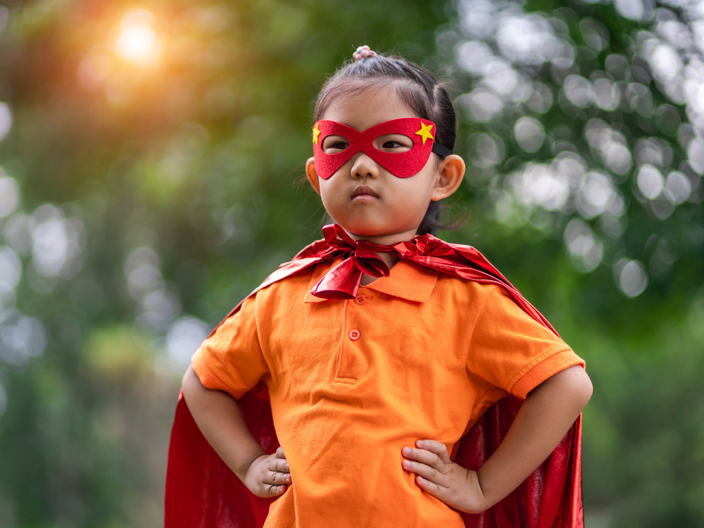 little girl posing in superhero costume