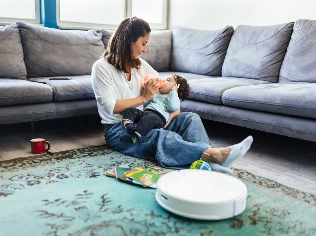 Woman on floor with robot vacuum