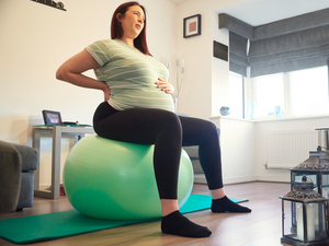 Pregnant woman sitting upright on an exercise ball