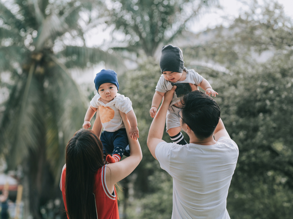 Couple holding their twin babies in the air