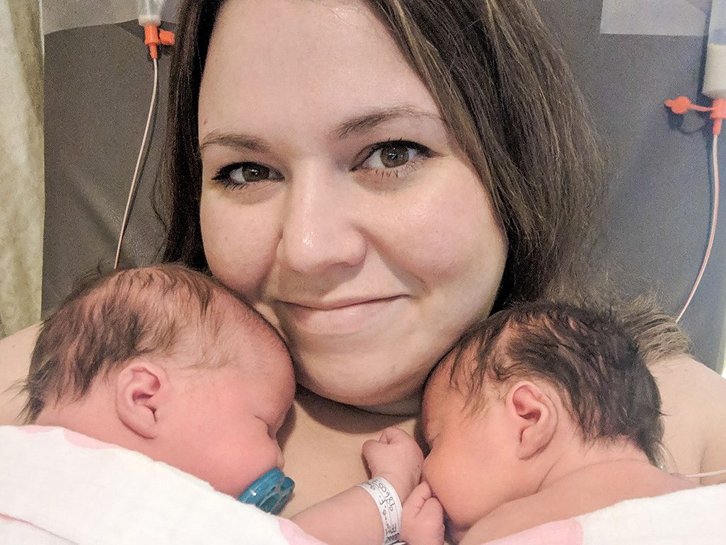 Mum with newborn twins laying next to her