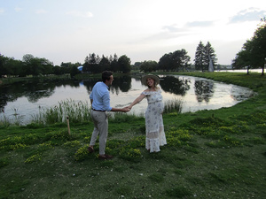 Pregnant woman smiling at partner by a lake