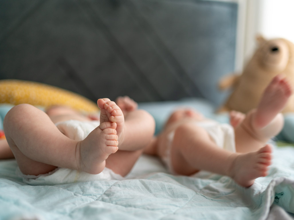 twin babies lying on a blanket