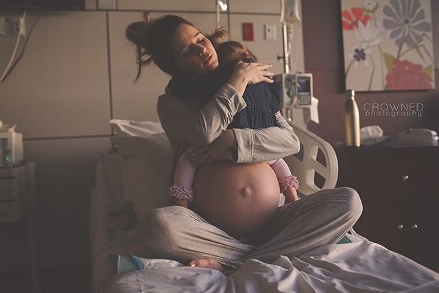 pregnant mother hugging daughter in a hospital bed