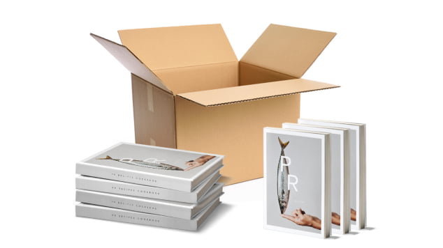 Professionally printed books in front of an open shipping box