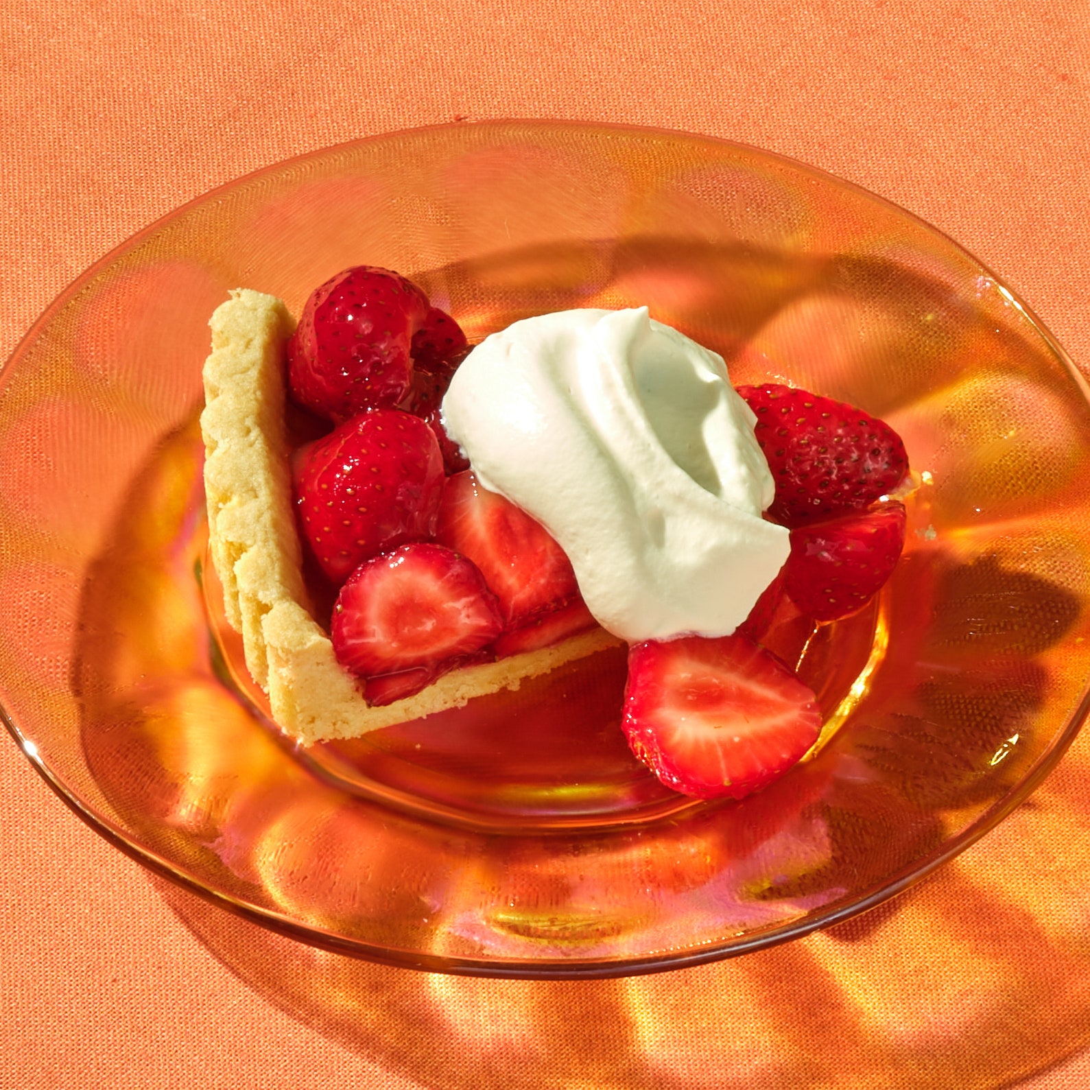 Fresh Strawberry Tart With Almond Crust on a glass plate