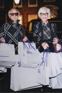 Shot of couple wearing Burberry Check Jackets, holding Burberry shopping bags