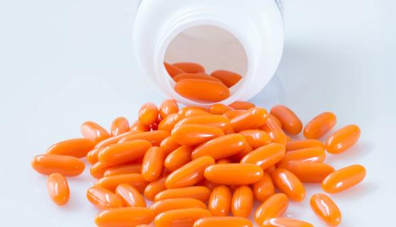 Orange capsules poured out of a bottle