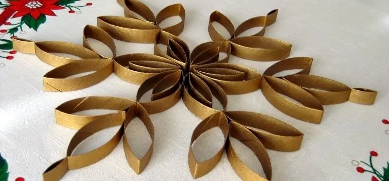 Gold paper quilling snowflake decoration on a festive table.