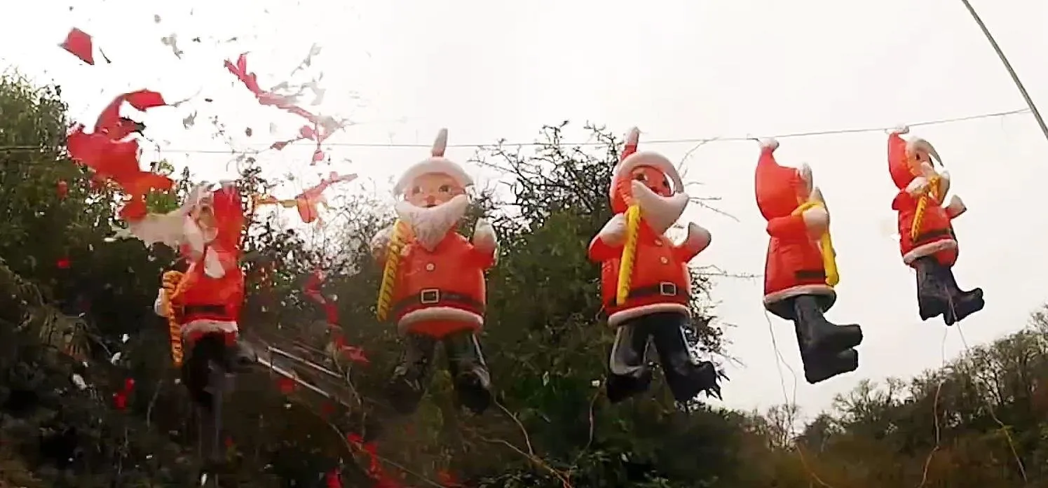 Festive Santa decorations hanging outdoors.