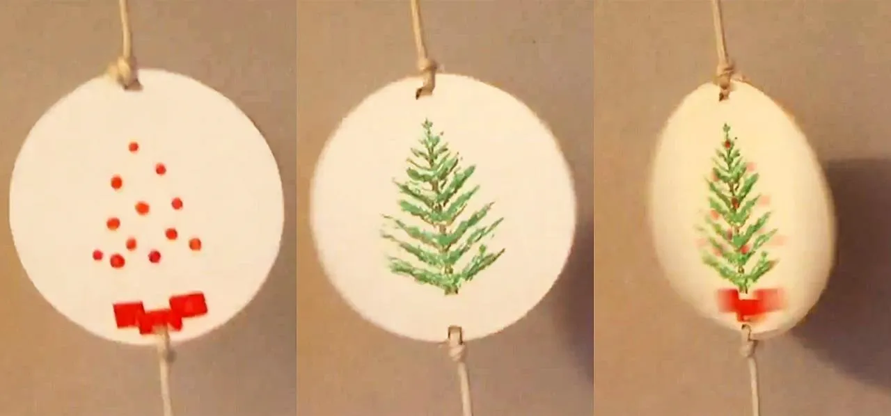 Handmade Christmas ornaments with red dots and a green tree design on a white background.