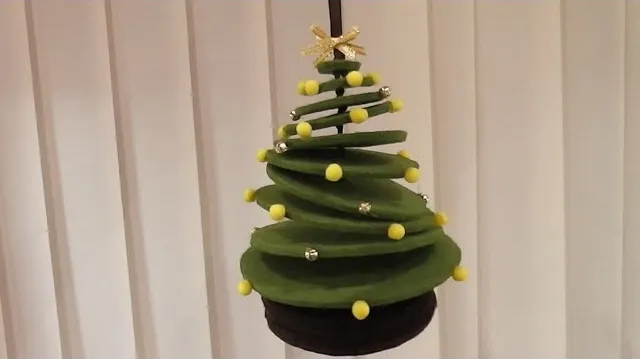 Decorative green Christmas tree with yellow ornaments.