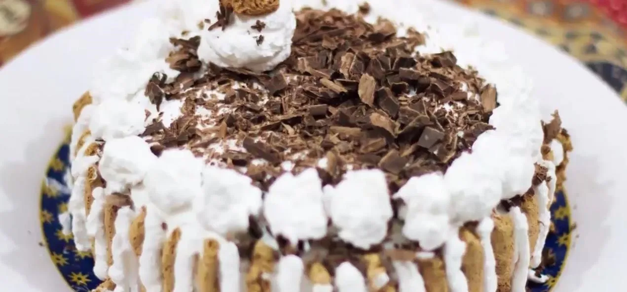 Chocolate cake topped with whipped cream and chocolate shavings.