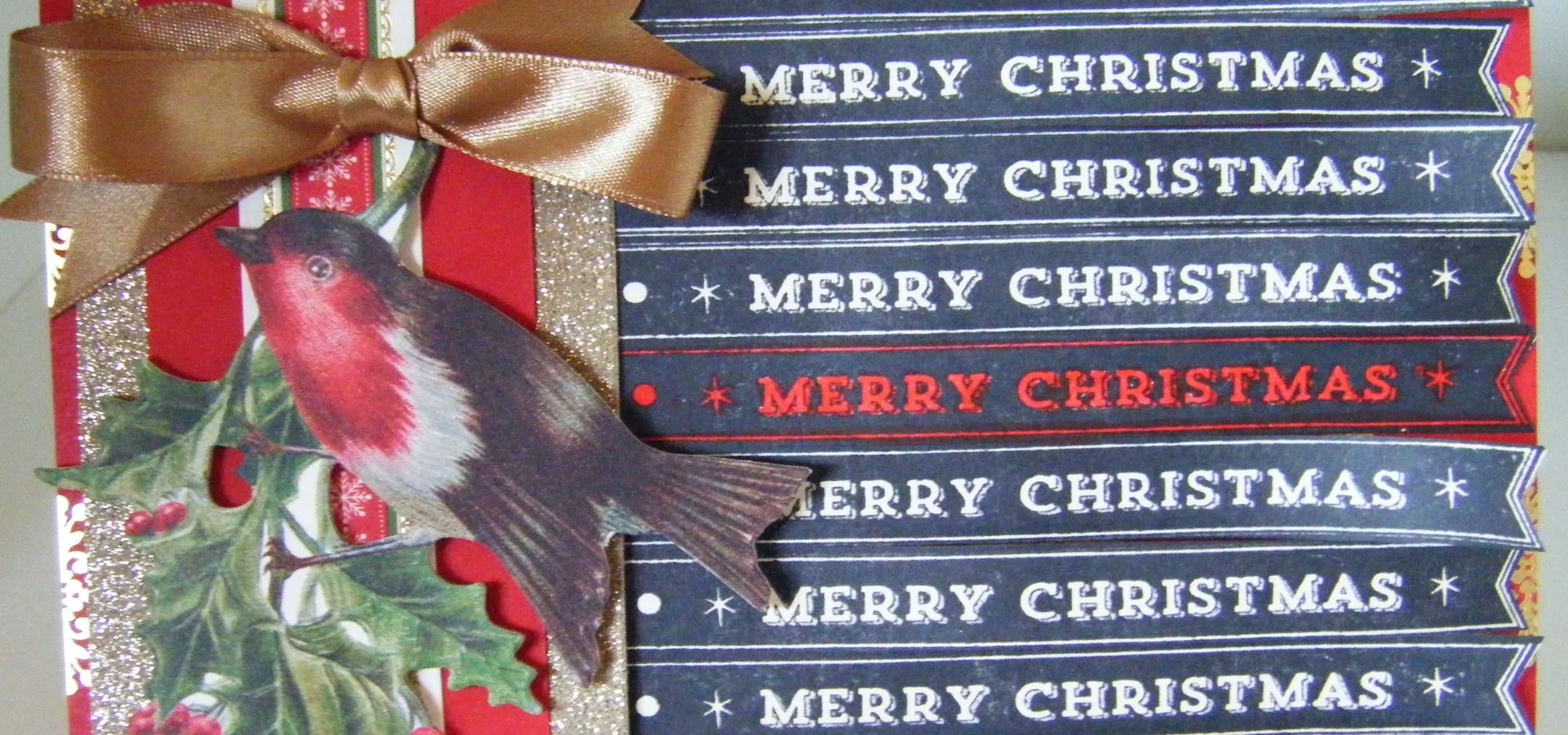 Christmas card featuring holly, a bird, and ribbons with the text "Merry Christmas."