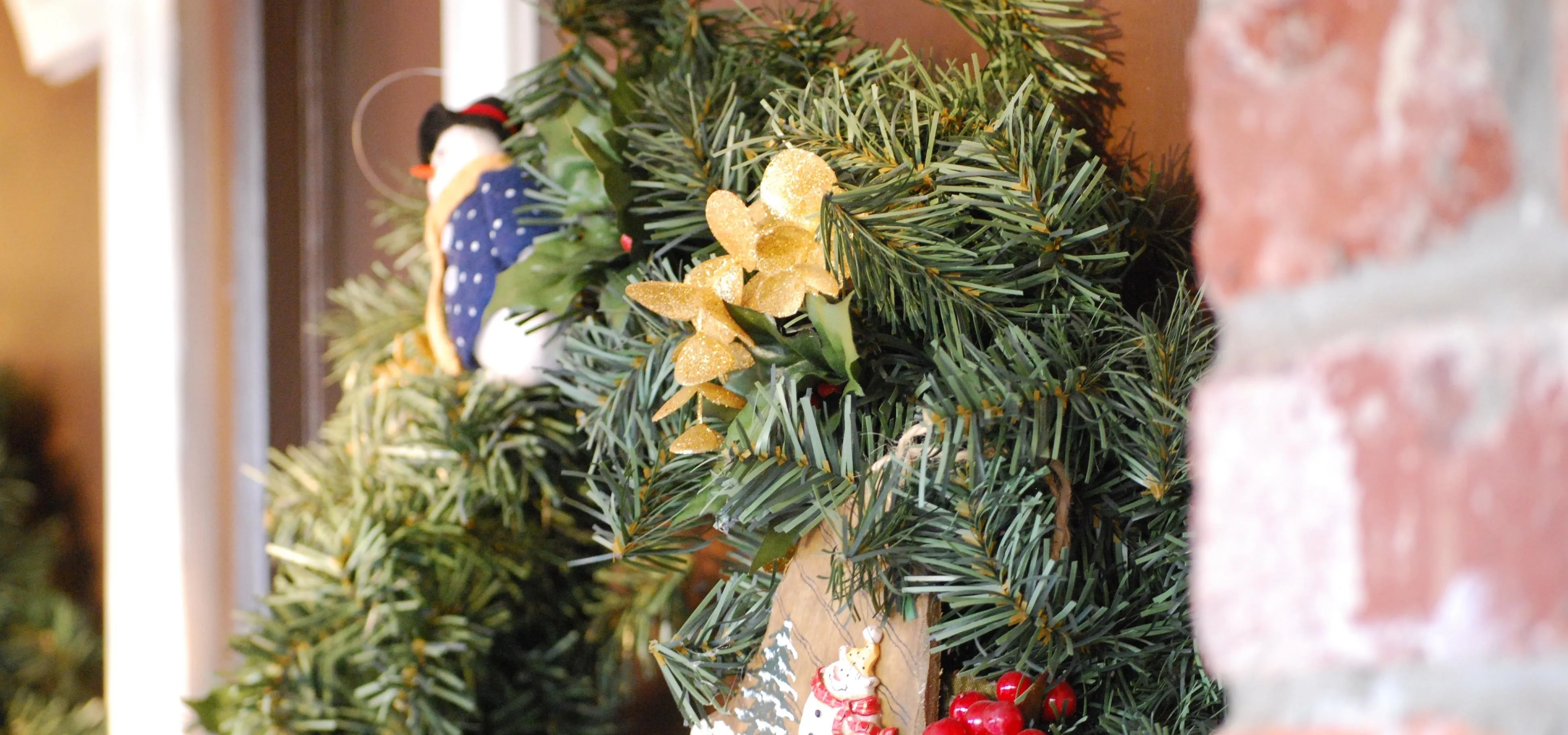 Festive wreath with yellow flowers and holiday decorations.