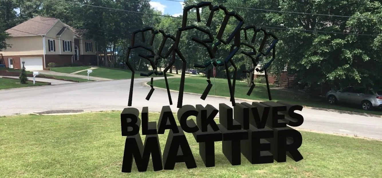 Black Lives Matter sign with raised fists in a residential setting.