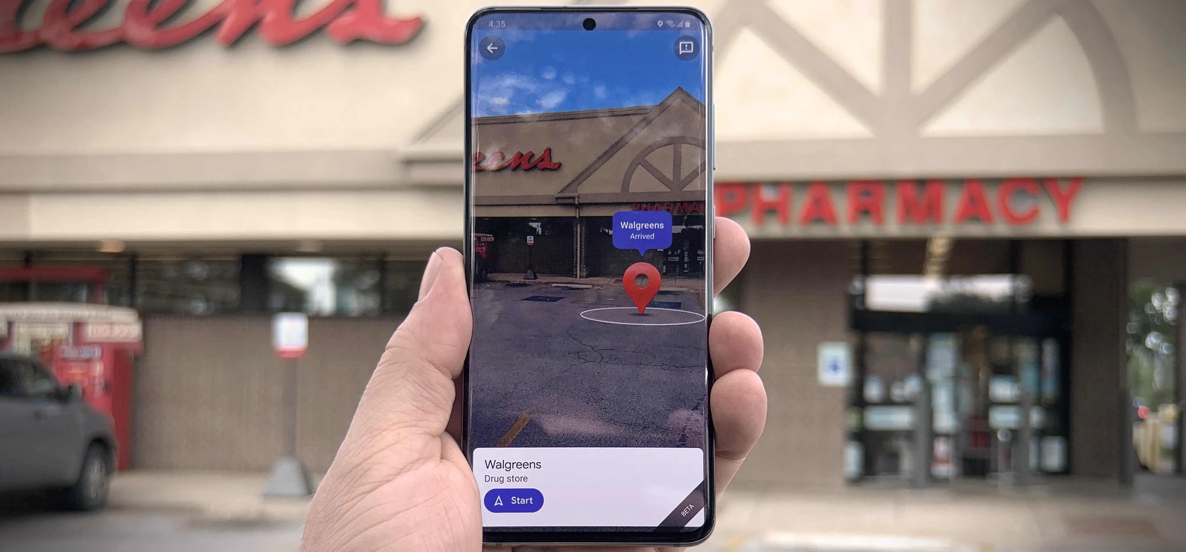 A person holding a smartphone displaying an augmented reality view of a pharmacy storefront.