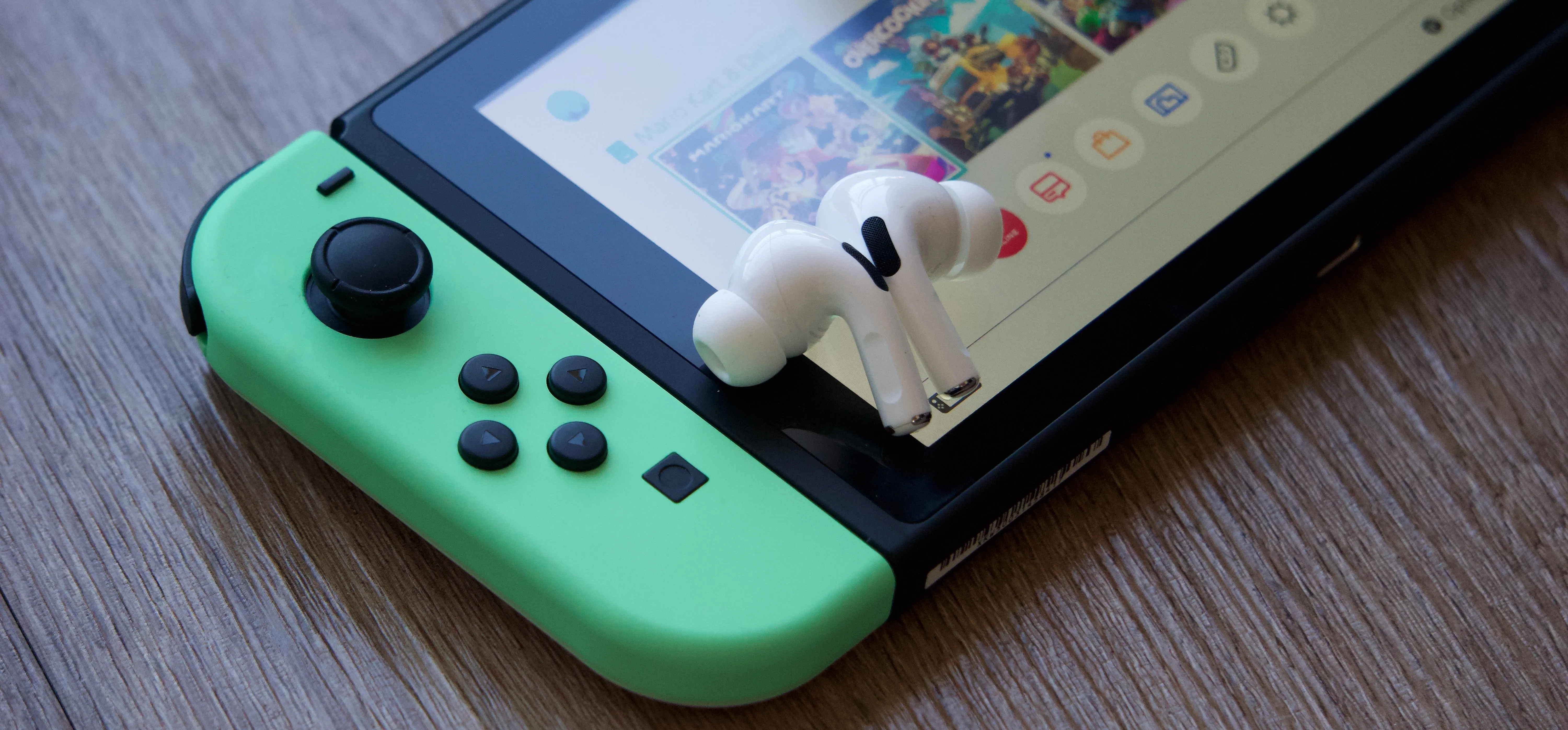 Nintendo Switch console with green grips and a character figure on top.