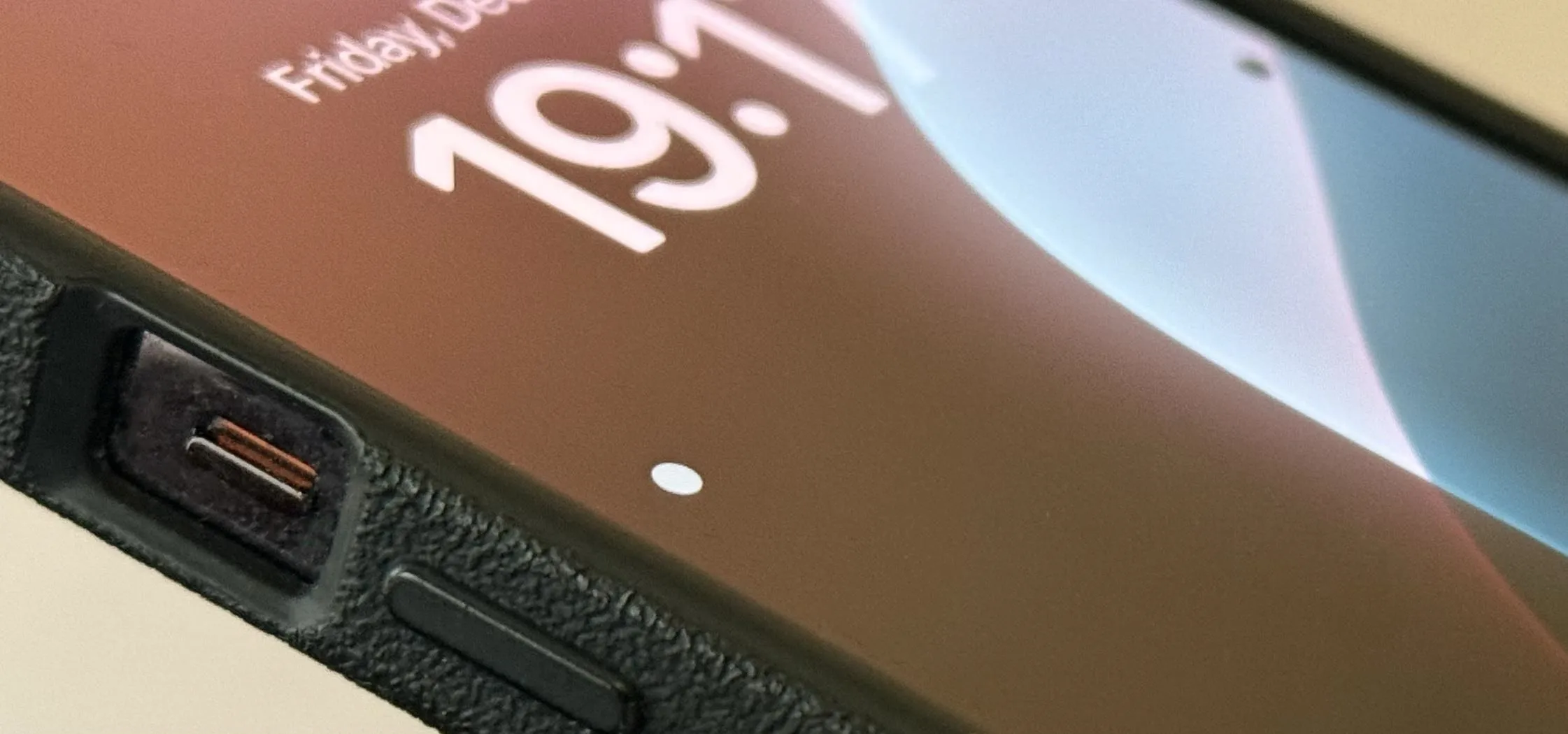 Close-up of a smartphone displaying the time and date on the lock screen.