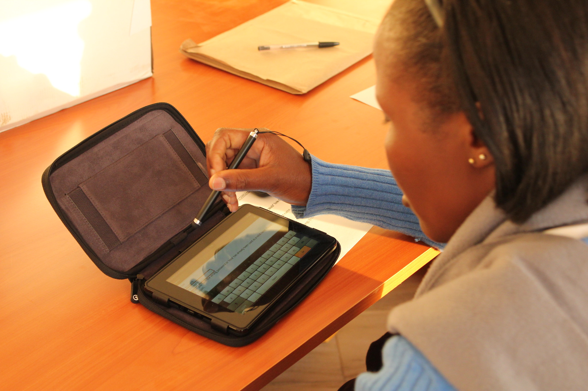 Une jeune femme utilisant sa tablette électronique pour étudier au Kenya. Crédit : GPE/Deepa Srikantaiah