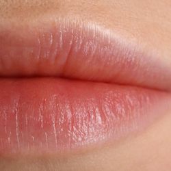 A macro photo showing a close up image of a woman's lips. 