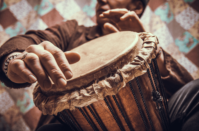 Male hands playing a traditional percussion drum musical instrument.