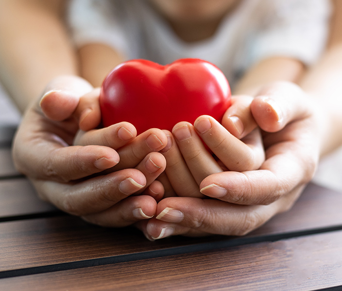 Mother and child cradling a toy heart in their hands