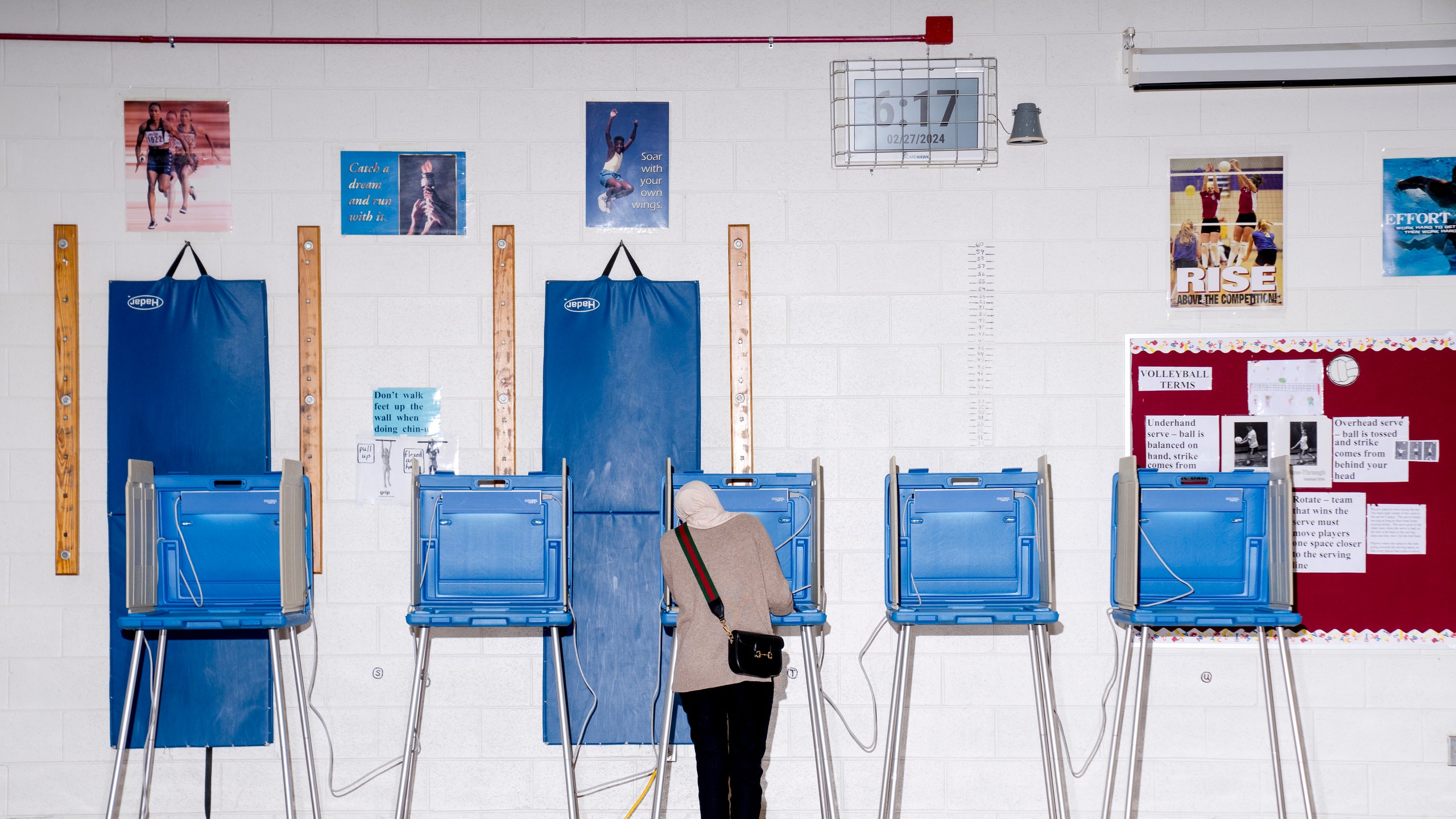 A voter casts their ballot at a polling station at William Ford Elementary School in Dearborn Michigan US on Tuesday...