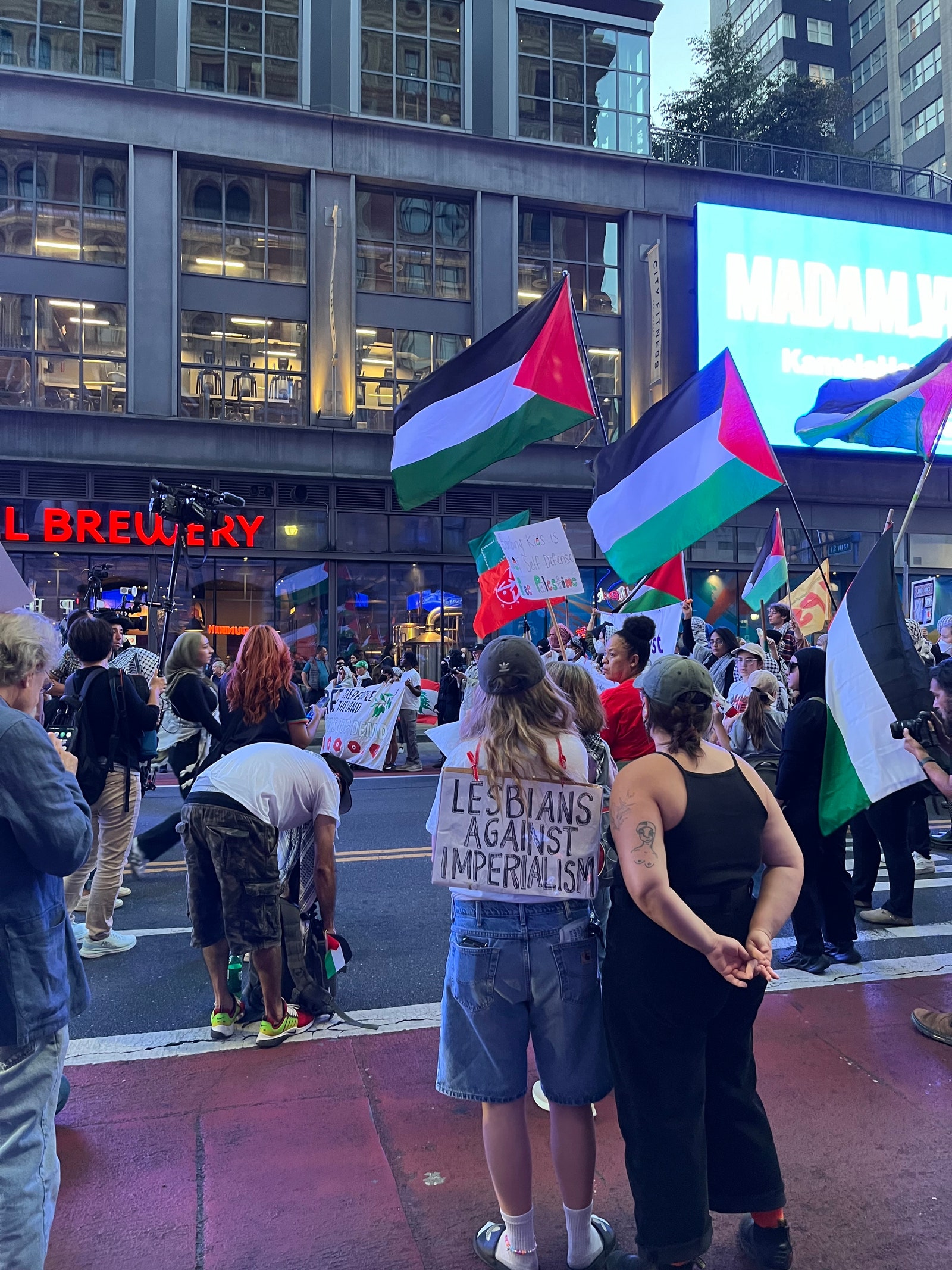 Protesters make their way down Philadelphia's Market Street. One wears a sign on their back reading “Lesbians Against...