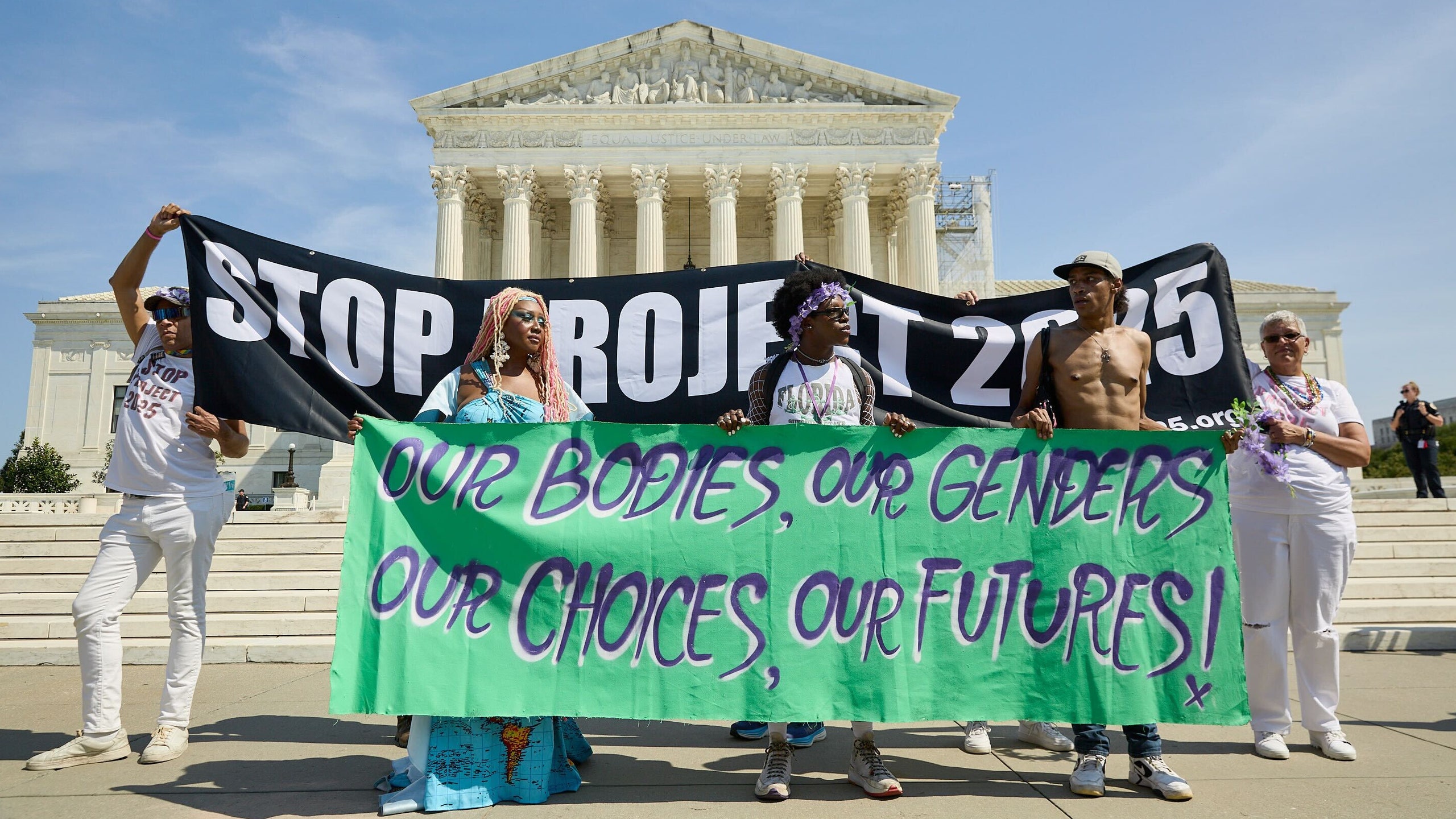 Protesters hold Stop Project 2025 and Our Bodies Our Genders Our Choices Our Futures banners in front of the Supreme Court