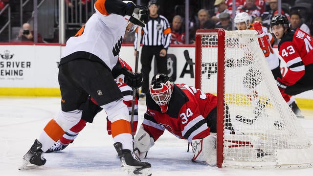 New Jersey Devils goaltender Jake Allen (34) stops a shot by Philadelphia Flyers center Sean Couturier (14) during a NHL game between the Philadelphia Flyers and New Jersey Devils at Prudential Center on January 29, 2025 in Newark, New Jersey. 