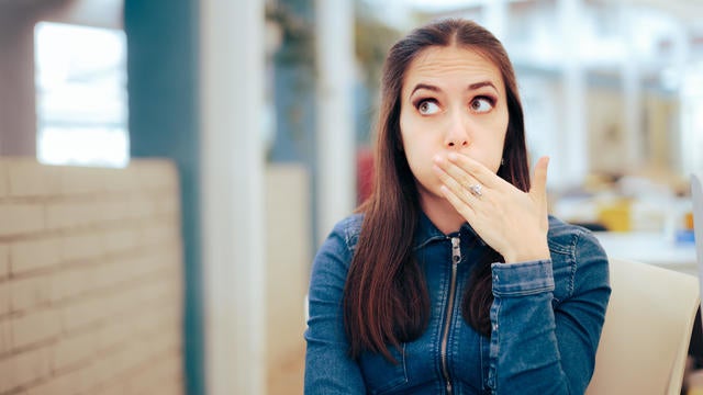 Woman Sitting in a Restaurant Feeling Sick and Nauseated 