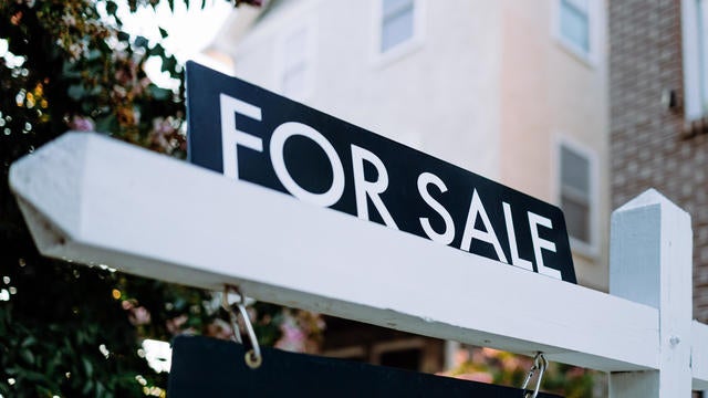 For Sale Sign in Front Yard of House 