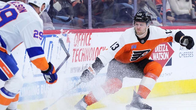 Philadelphia Flyers' Adam Ginning, right, tries to get the puck away from New York Islanders' Brock Nelson during the first period of an NHL hockey game 